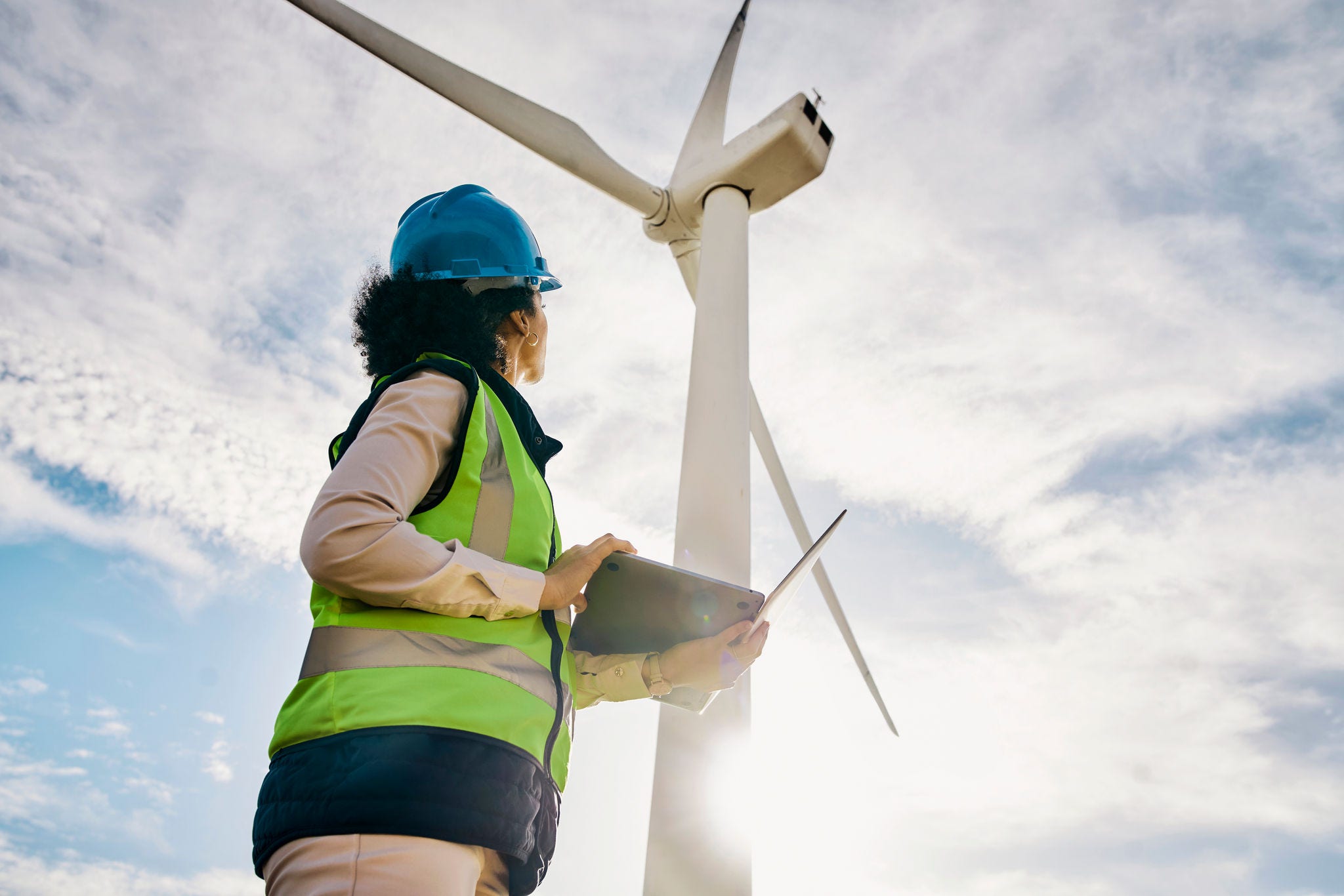 1463616218 Engineer woman, wind turbine and laptop on farm for renewable energy, power and electricity. Electrician or technician in nature for windmill, eco and green environment inspection and maintenace