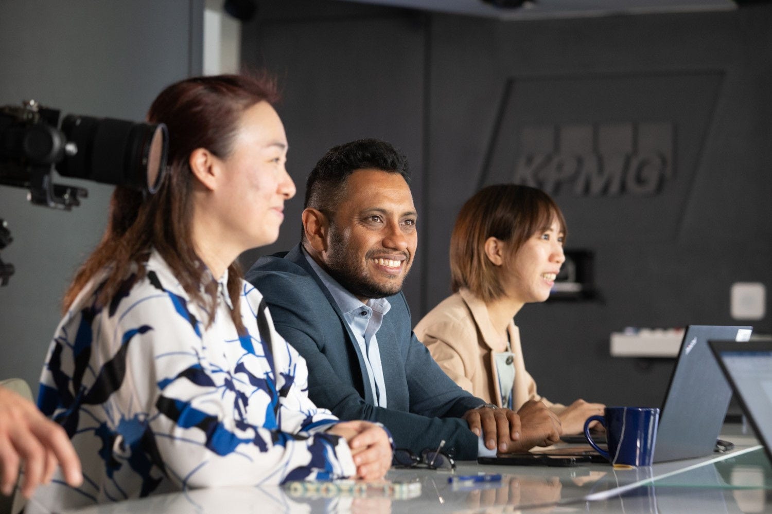 Three people in KPMG office Three people in KPMG office